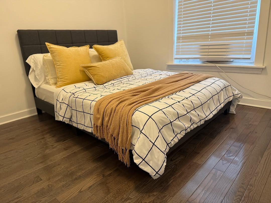 Clean bedroom with made bed and yellow pillows
